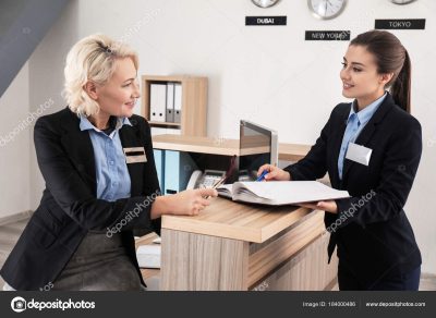 Female receptionist teaching trainee in hotel