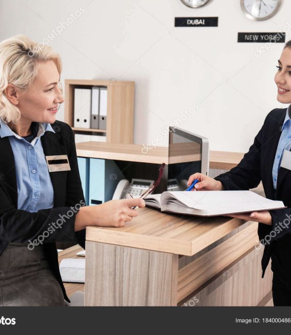 Female receptionist teaching trainee in hotel